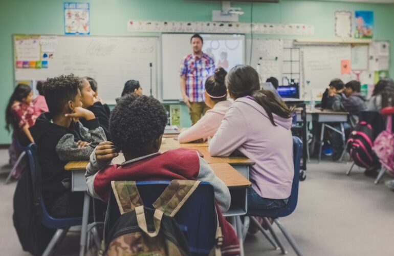 Teacher in a classroom full of enthusiastic learners.