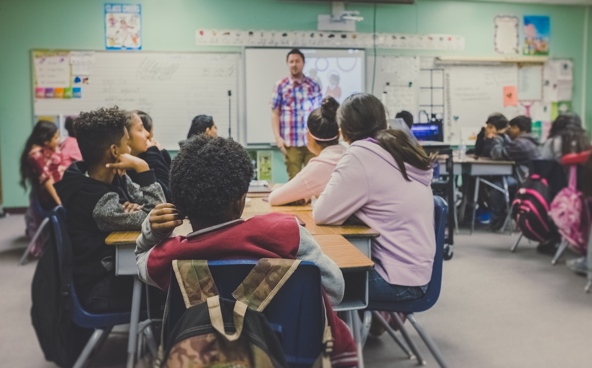 Teacher in a classroom full of enthusiastic learners.